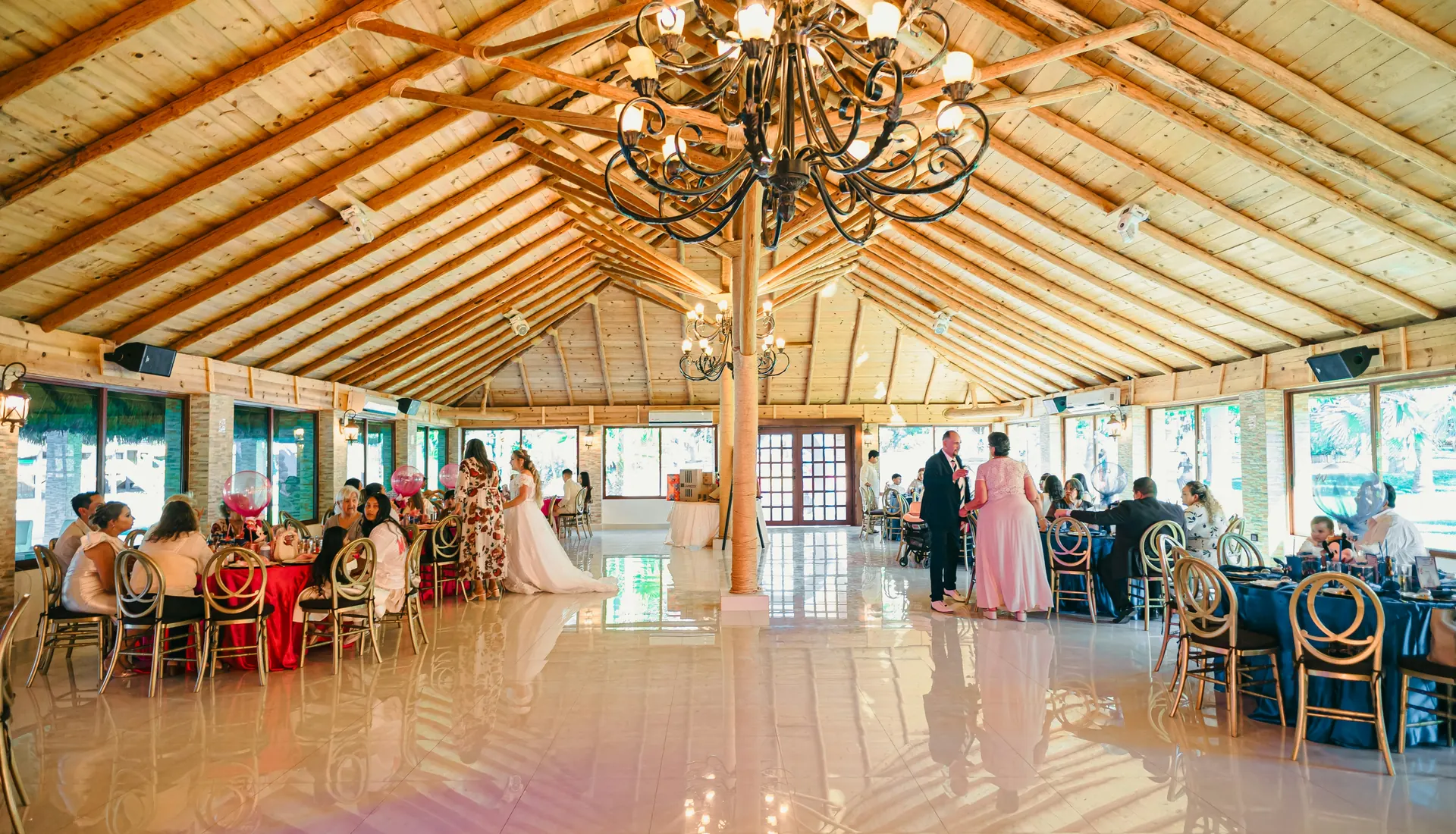 Salón de celebraciones con techo de madera y lámpara de araña